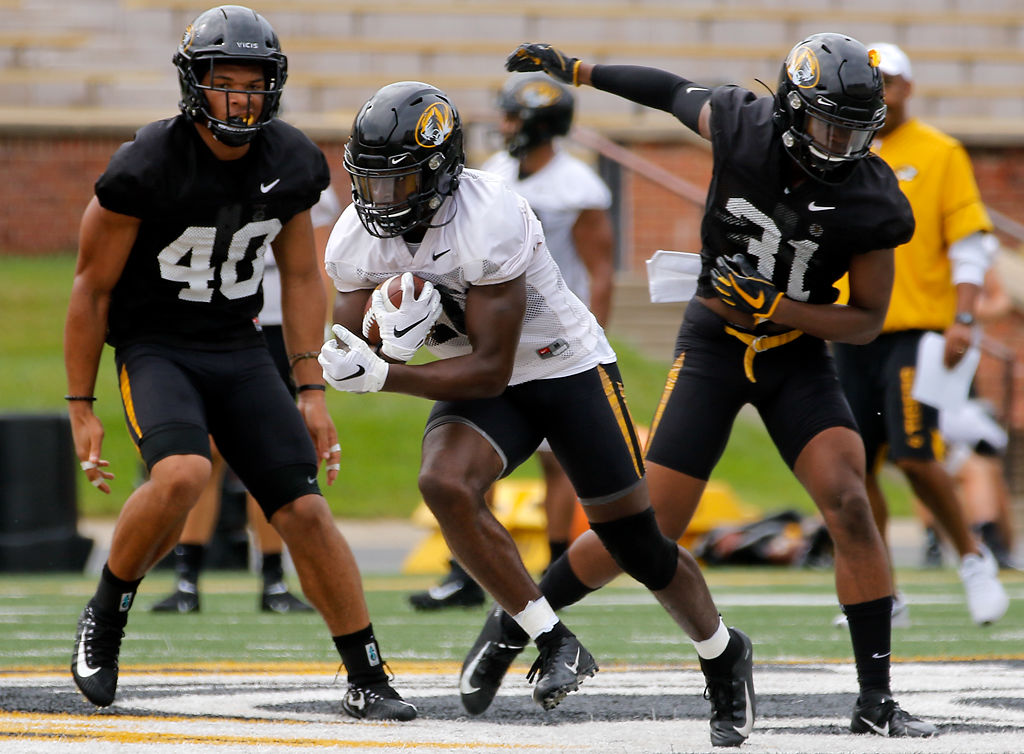 Simi Bakare, center, sprints past Cameron Wilkins, left, and Martez Manuel